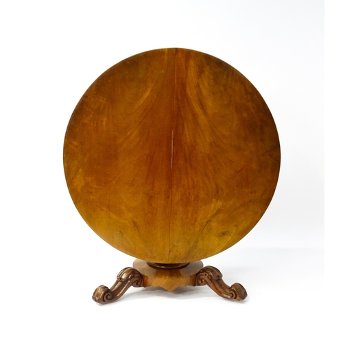 1564 - A 19thC mahogany tilt top breakfast table with a carved frieze above a turned and carved pedestal ba... 