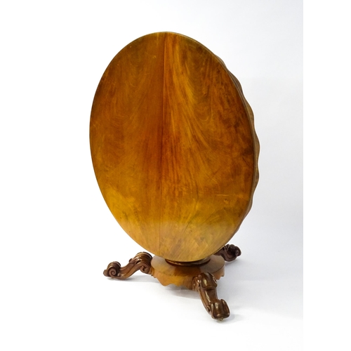 1564 - A 19thC mahogany tilt top breakfast table with a carved frieze above a turned and carved pedestal ba... 