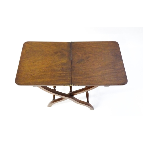 1565 - A Georgian mahogany coaching table / metamorphic table with a hinged top and folding base formed fro... 