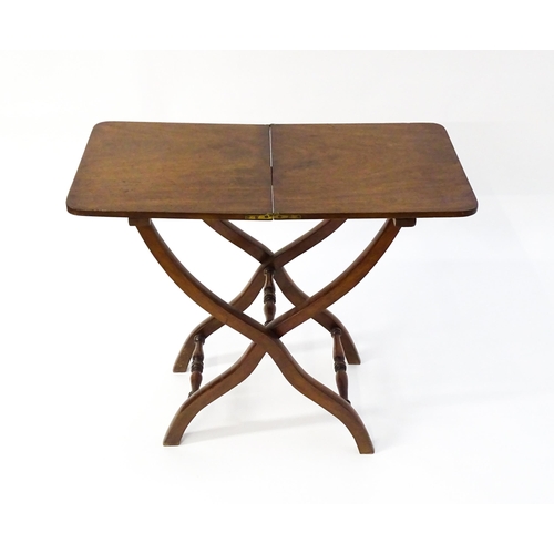 1565 - A Georgian mahogany coaching table / metamorphic table with a hinged top and folding base formed fro... 