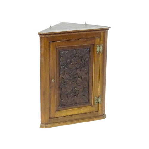 1570 - An Aesthetic period walnut corner cupboard with a carved door showing carved floral decoration. 22