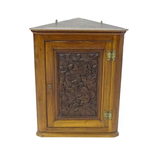 1570 - An Aesthetic period walnut corner cupboard with a carved door showing carved floral decoration. 22