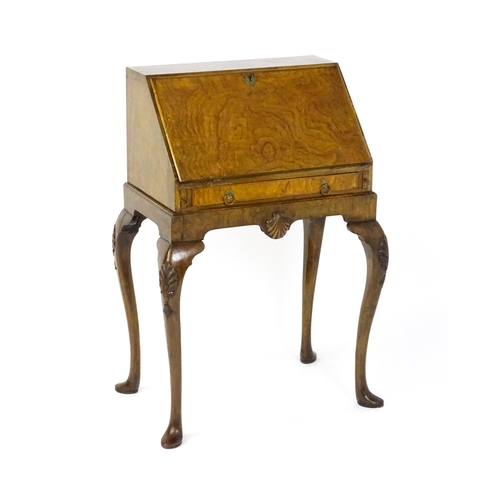 1572 - An Edwardian Queen Anne style walnut bureau on stand, the fall front opening to show pigeon holes,  ... 