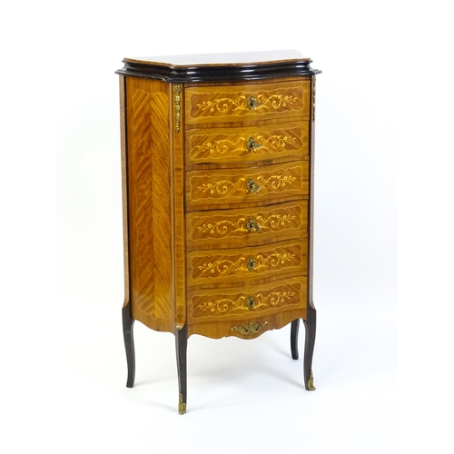 1576 - A mid 20thC kingwood chest of drawers with a serpentine shaped front above six short drawers inlaid ... 