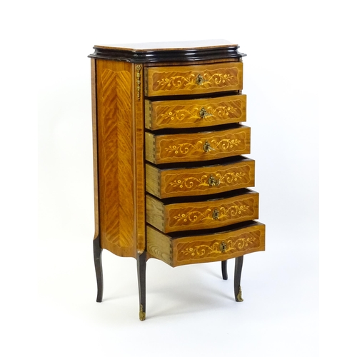 1576 - A mid 20thC kingwood chest of drawers with a serpentine shaped front above six short drawers inlaid ... 