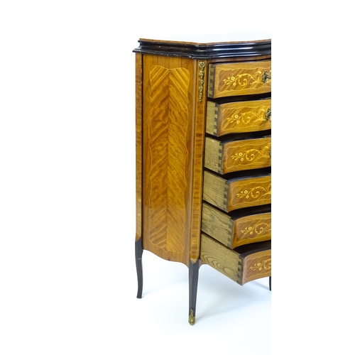 1576 - A mid 20thC kingwood chest of drawers with a serpentine shaped front above six short drawers inlaid ... 