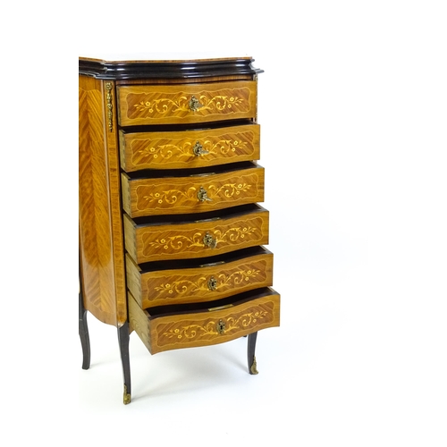 1576 - A mid 20thC kingwood chest of drawers with a serpentine shaped front above six short drawers inlaid ... 