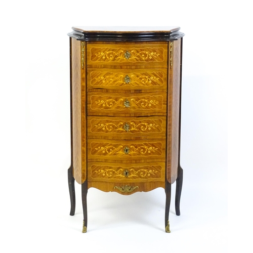 1576 - A mid 20thC kingwood chest of drawers with a serpentine shaped front above six short drawers inlaid ... 