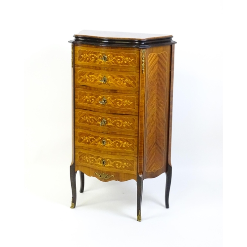 1576 - A mid 20thC kingwood chest of drawers with a serpentine shaped front above six short drawers inlaid ... 