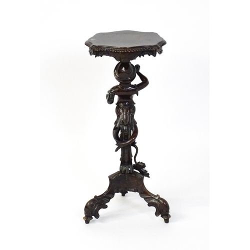 1581 - A 19thC side table with a shaped top above a carved caryatid style figural pedestal grasping a bunch... 