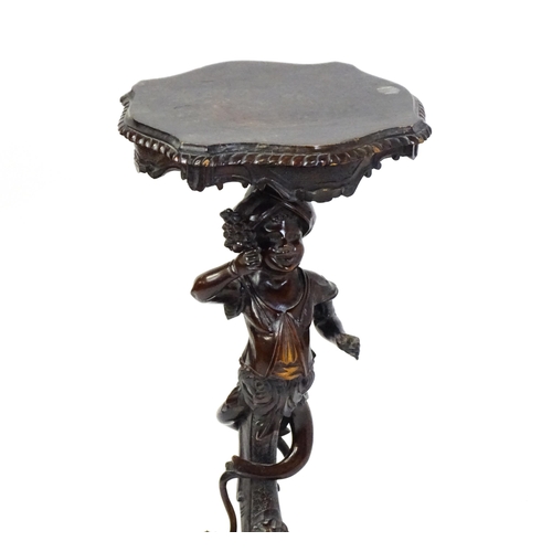 1581 - A 19thC side table with a shaped top above a carved caryatid style figural pedestal grasping a bunch... 