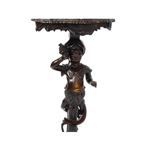 1581 - A 19thC side table with a shaped top above a carved caryatid style figural pedestal grasping a bunch... 