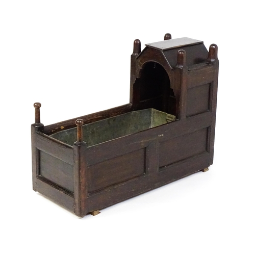 1586 - A mid / late 18thC oak cradle / crib / wine cooler with turned posts and a panelled structure, the i... 