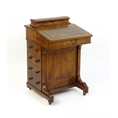 1587 - A mid / late 19thC walnut Davenport surmounted by a hinged writing compartment. The writing slope ha... 