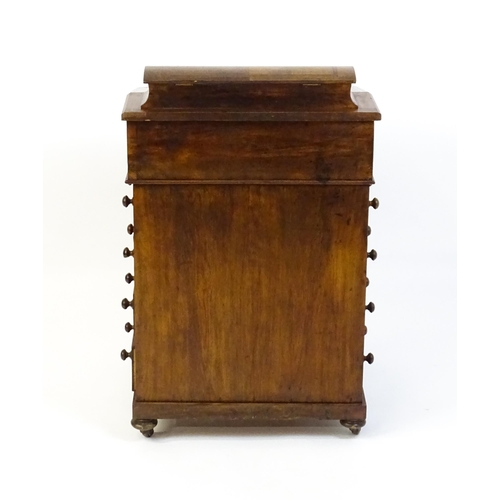 1587 - A mid / late 19thC walnut Davenport surmounted by a hinged writing compartment. The writing slope ha... 