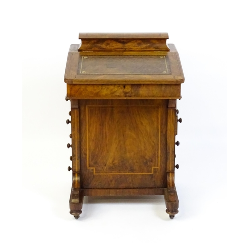 1587 - A mid / late 19thC walnut Davenport surmounted by a hinged writing compartment. The writing slope ha... 