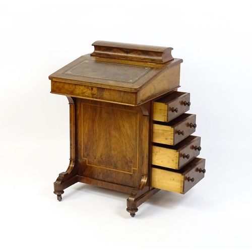 1587 - A mid / late 19thC walnut Davenport surmounted by a hinged writing compartment. The writing slope ha... 