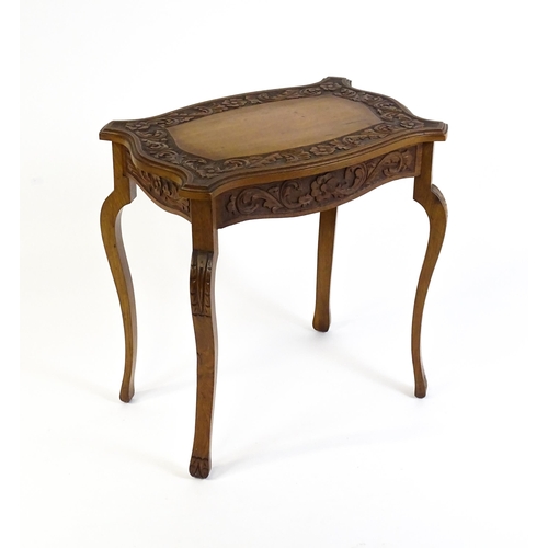 1588 - A mid 20thC walnut side table with a floral carved top and frieze raised on four cabriole legs. 27