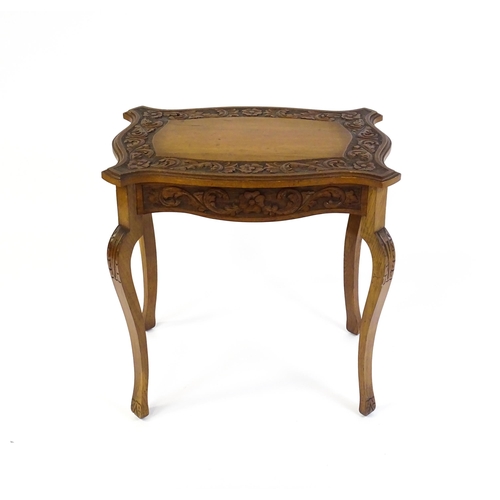 1588 - A mid 20thC walnut side table with a floral carved top and frieze raised on four cabriole legs. 27