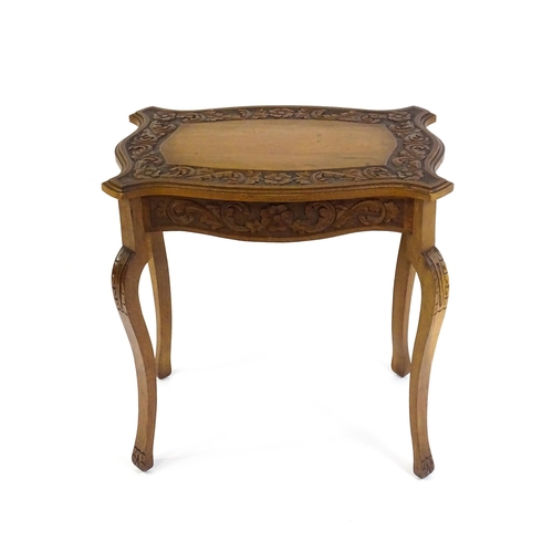 1588 - A mid 20thC walnut side table with a floral carved top and frieze raised on four cabriole legs. 27