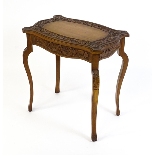 1588 - A mid 20thC walnut side table with a floral carved top and frieze raised on four cabriole legs. 27