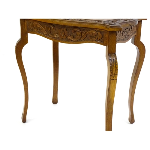 1588 - A mid 20thC walnut side table with a floral carved top and frieze raised on four cabriole legs. 27