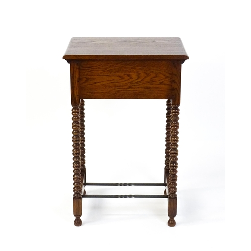 1591 - A mid 20thC oak side table with a moulded top above a short frieze drawer above four bobbin turned l... 