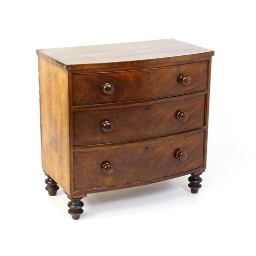 1594 - A late 18thC / early 19thC mahogany bow fronted chest of drawers comprising three long drawers raise... 