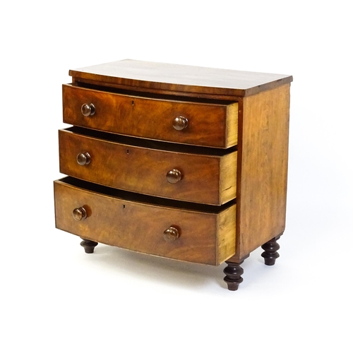 1594 - A late 18thC / early 19thC mahogany bow fronted chest of drawers comprising three long drawers raise... 