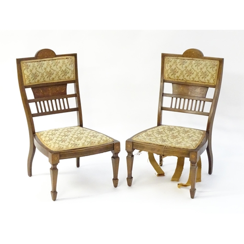 1603 - A pair of Edwardian walnut side chairs with satinwood marquetry decoration raised on tapering legs t... 