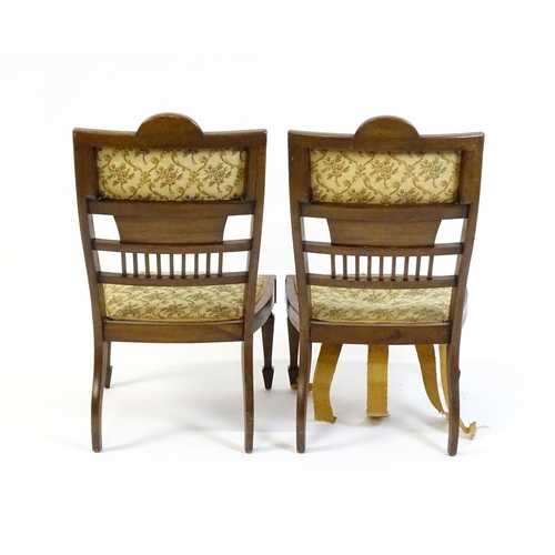 1603 - A pair of Edwardian walnut side chairs with satinwood marquetry decoration raised on tapering legs t... 