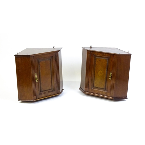 1604 - A pair of mid 20thC walnut corner cabinets. Bearing labels to back panels. 21 1/2 high x 26