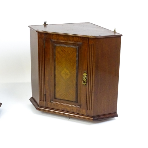 1604 - A pair of mid 20thC walnut corner cabinets. Bearing labels to back panels. 21 1/2 high x 26