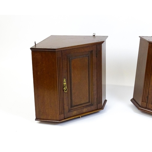 1604 - A pair of mid 20thC walnut corner cabinets. Bearing labels to back panels. 21 1/2 high x 26