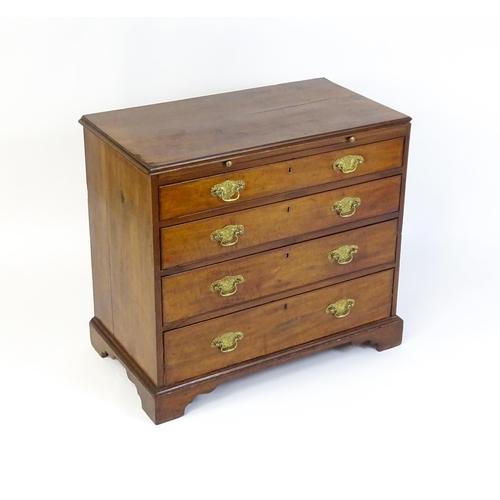 1611 - A George III mahogany chest of drawers comprising a brushing slide over four long drawers with embos... 