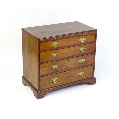 1611 - A George III mahogany chest of drawers comprising a brushing slide over four long drawers with embos... 