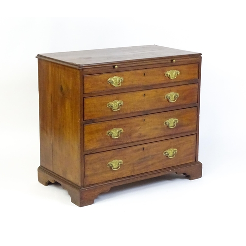 1611 - A George III mahogany chest of drawers comprising a brushing slide over four long drawers with embos... 