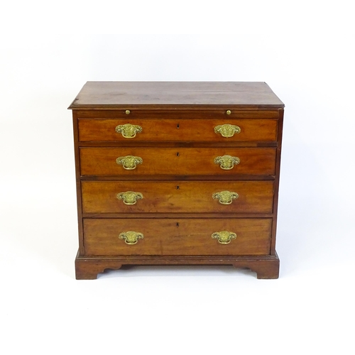 1611 - A George III mahogany chest of drawers comprising a brushing slide over four long drawers with embos... 