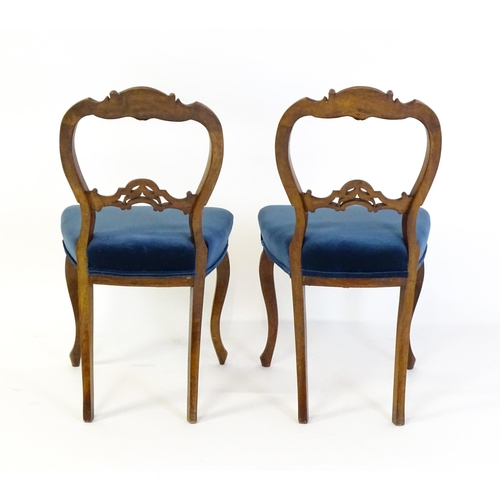 1616 - A pair of 19thC walnut balloon back dining side chairs with carved, pierced mid rails and raised on ... 