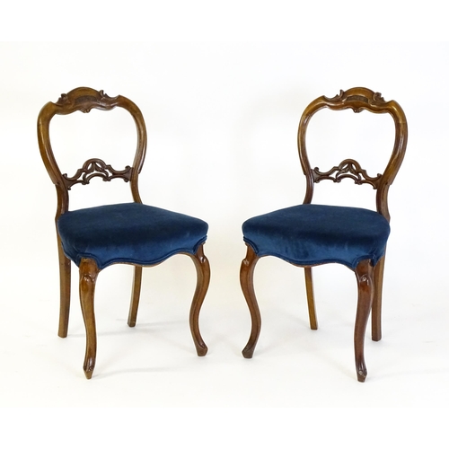 1616 - A pair of 19thC walnut balloon back dining side chairs with carved, pierced mid rails and raised on ... 