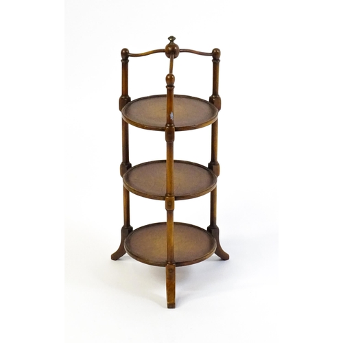 1619 - A mid 20thC walnut three tier cake stand with leather topped circular shelves. 26