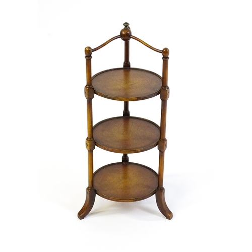 1619 - A mid 20thC walnut three tier cake stand with leather topped circular shelves. 26