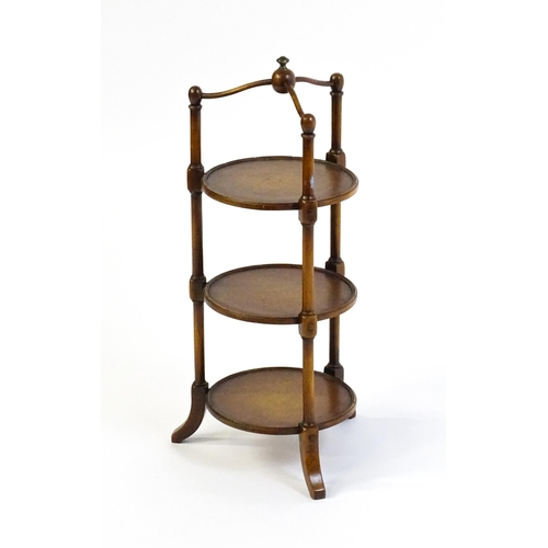 1619 - A mid 20thC walnut three tier cake stand with leather topped circular shelves. 26