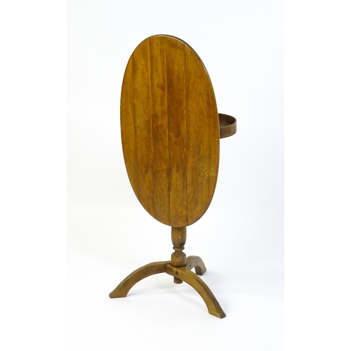 1621 - An early 20thC New England style occasional table, with an oval planked top, a storage compartment b... 