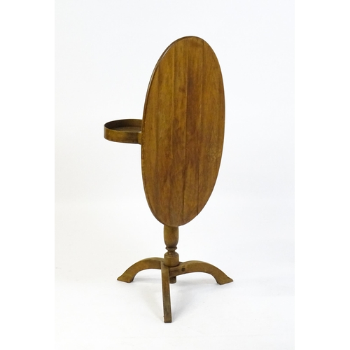 1621 - An early 20thC New England style occasional table, with an oval planked top, a storage compartment b... 