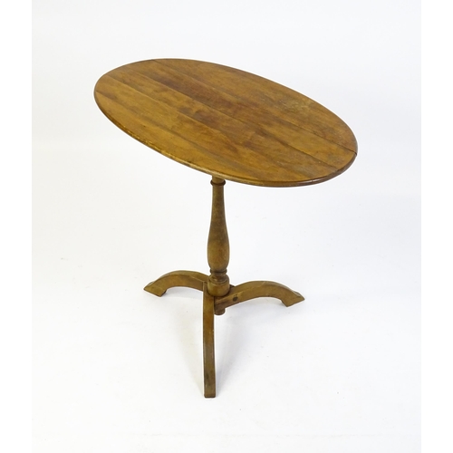 1621 - An early 20thC New England style occasional table, with an oval planked top, a storage compartment b... 