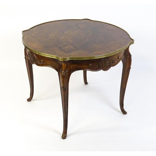 1623 - A Louis XV style centre table with a brass surround and a burr walnut veneered top above four carved... 