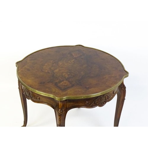 1623 - A Louis XV style centre table with a brass surround and a burr walnut veneered top above four carved... 