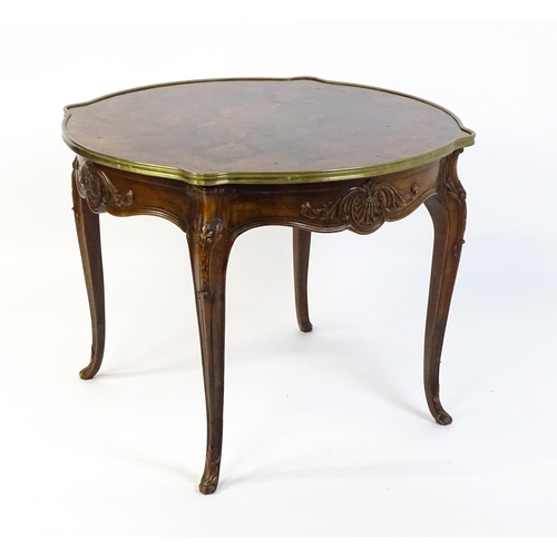 1623 - A Louis XV style centre table with a brass surround and a burr walnut veneered top above four carved... 