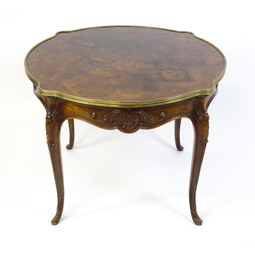 1623 - A Louis XV style centre table with a brass surround and a burr walnut veneered top above four carved... 